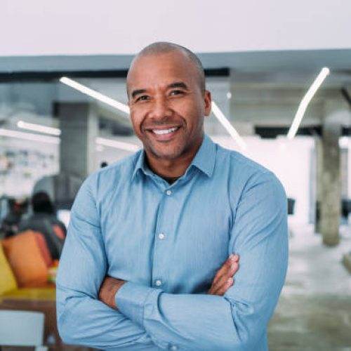 Portrait of handsome confident smiling businessman standing in the office and looking at camera.